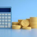 Fluturaș de salariu tipărit pe un birou, alături de un calculator și un pix pentru verificarea sumelor
